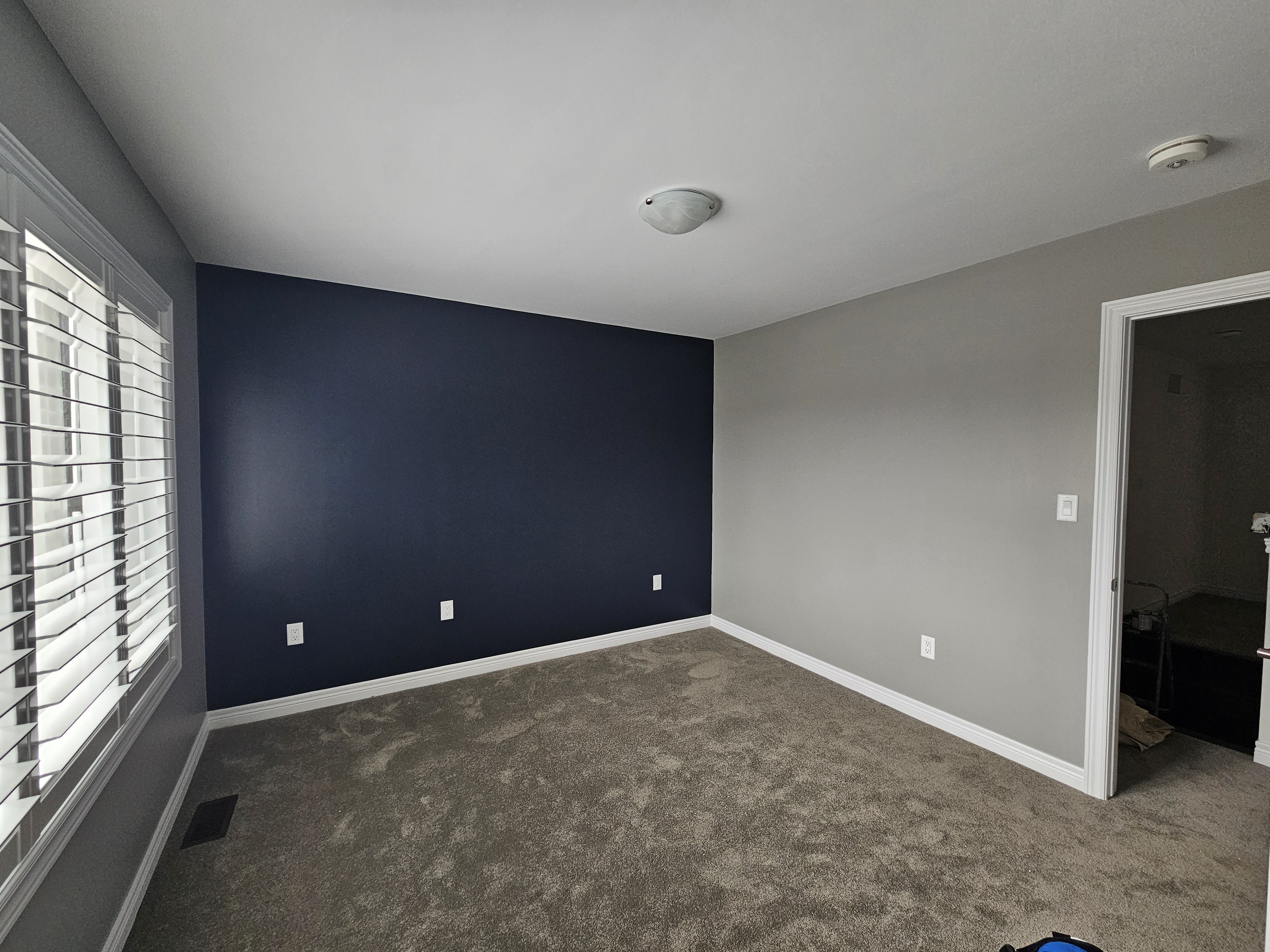 this interior paint job is a bedroom painted in balboa mist from benjamin moore with an accent wall painted in hale navy